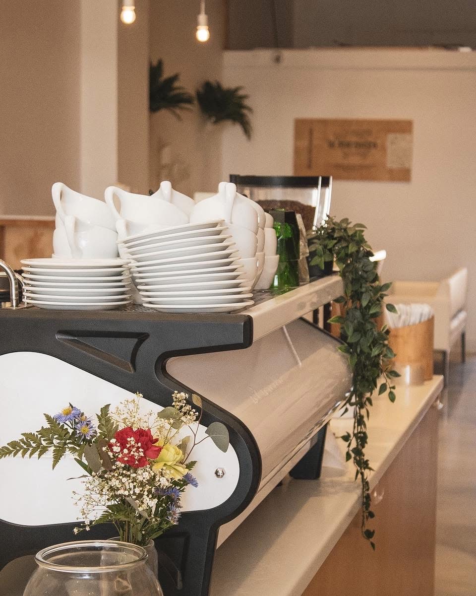 Ceramic cups and greenery on the espresso bar.