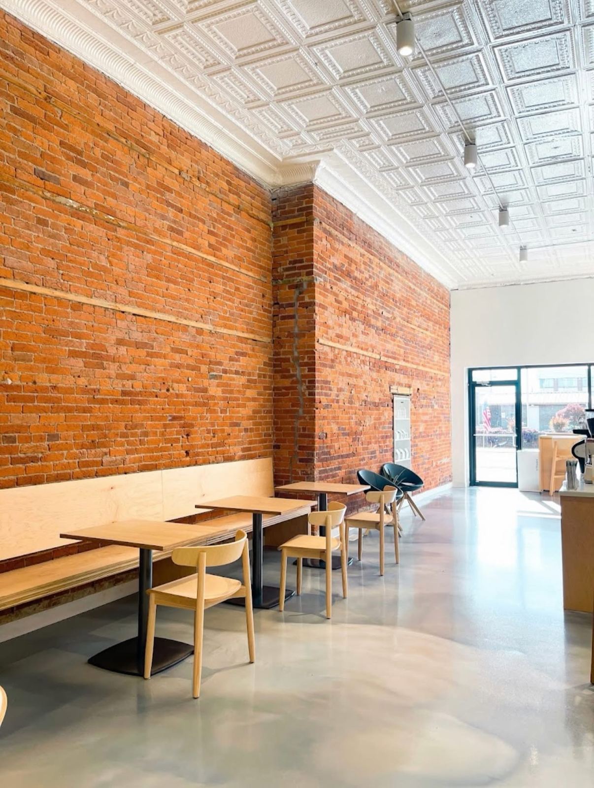 Exposed brick wall and oak tables inside Fusion Coffee.
