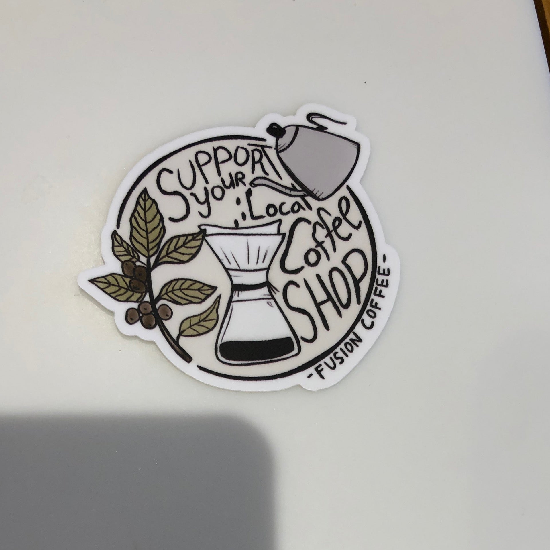 Hand-drawn sticker of a pour-over Chemex and gooseneck kettle with a coffee branch reading “Support Your Local Coffee Shop, Fusion Coffee.”